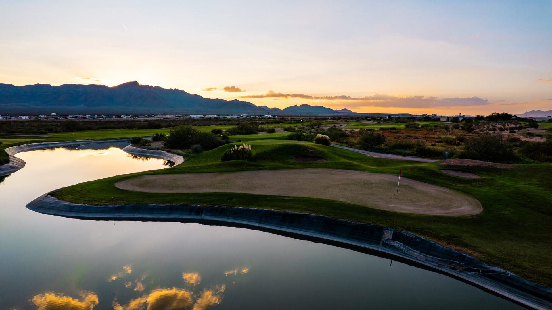 Sunset over a pond and green at the Painted Dunes golf facility in El Paso.