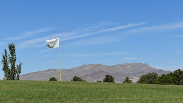 Flag on a green at Ascarate Golf Course with El Paso mountains in the background.