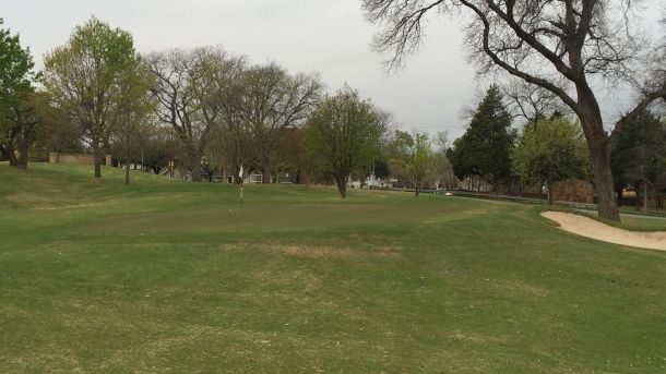 Green and sand bunker framed by mature trees at Tenison Highlands in Dallas.
