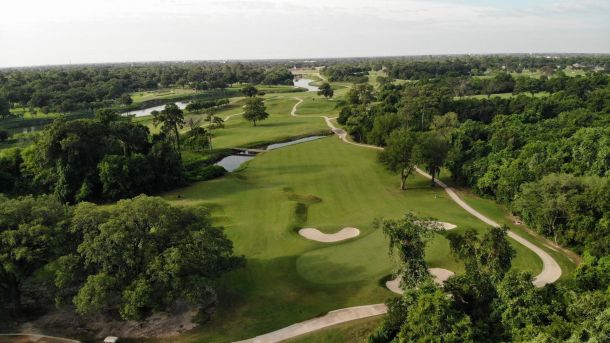 Aerial view of tree-lined fairways and sand bunkers at Gus Wortham Golf Course in Houston.